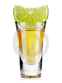 Gold tequila shot with lime isolated on white