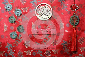 Gold tiger symbol, five lucky coins with chinese zodiac, fortune hunger from lucky coins on red fabric with traditional chinese