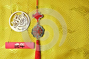 Gold tiger symbol, fortune hunger from lucky coins on yellow fabric with traditional chinese ornament with clouds. Copyspace.