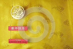 Gold tiger symbol on yellow fabric with traditional chinese ornament with clouds. Chinese New Year of the Tiger 2022. Translation