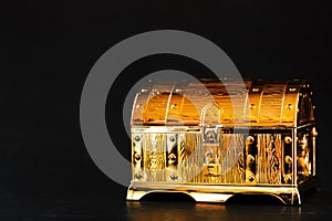 Gold treasure chest on a black textured background