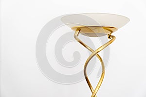 A Gold Twisted Metal Modern Design Household Lamp Stand With A Glass Shade Isolated On White With Copy Space