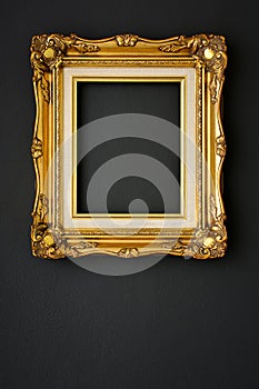 Gold vintage picture frame on black color wall background, copy space, funeral and mourning concept