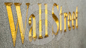 Gold Wall Street name chiseled into stone wall.