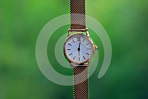 Gold watch and quartz on a green background