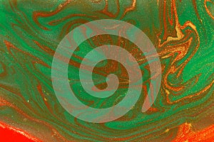 Gold waves on flow red and green paints abstract background.