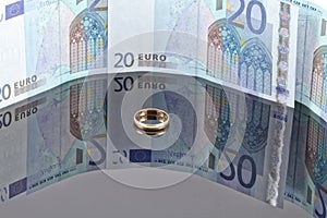 Gold wedding ring on the background of Euro banknotes