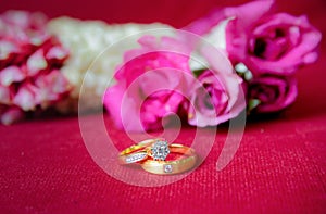 Gold wedding ring and red roses