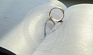 A gold wedding ring stands in a weekly