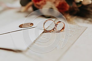 gold wedding rings near the envelope with wedding vows. Selective focus