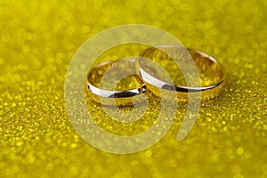 Gold wedding rings for newlyweds on a background