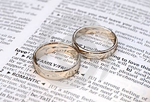 Gold wedding rings on a page showing love