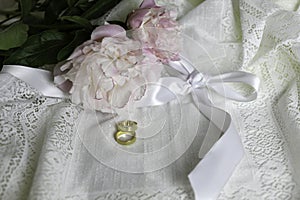 Gold wedding rings, satin bow and lace