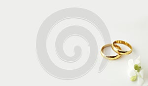 Gold wedding rings with small flowers on off white background Wedding invitation card generative ai illustration