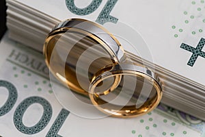 Gold wedding rings surrounded by a stack of Polish banknotes