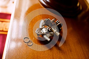 Gold wedding rings on a wooden table with a sextant navigational measuring instrument.