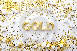 Gold and white confetti scattered on a white background. Festive confetti creates a celebratory atmosphere. Gold confetti adds photo