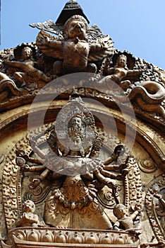 Gold-winged bird and big black sky statue along Nepal temple door