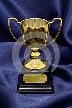 Gold Winners trophy on silk background