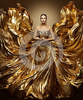 Gold woman flying dress, fashion model in waving art golden gown