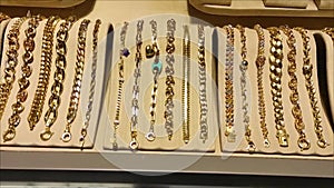 Gold women\'s bracelets with precious stones on the jewelry store window