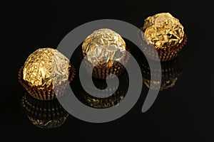 Gold wrapped candy islated on black background