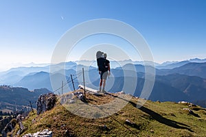 Goldeck - Man with baby carrier looking at magical mountain peaks of Karawanks and Julian Alps seen from Goldeck