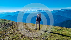 Goldeck - Man with baby carrier looking at magical mountain peaks of Karawanks and Julian Alps seen from Goldeck