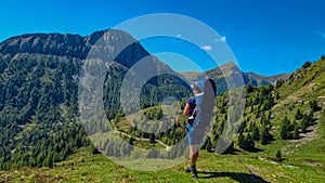 Goldeck - Man with baby carrier looking at majestic mountain peak Staff seen from Seetalnock, Goldeck, Latschur group