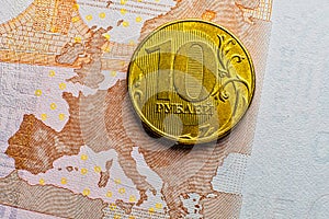 Golden 10 RUR russian ruble coin over euro banknote macro image - depicting EU economy crisis and recession by sanctions