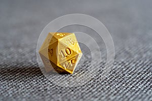 Golden 3D printed d20 RPG game dice on a bed object macro detail, extreme closeup, nobody. Playing tabletop RPG board games, larp