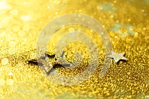 Golden abstract background with stars, lights, bokeh. Christmas celebration. Glitter texture card for new year party