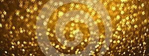 Golden abstract magic winter background, banner, panorama with defocused lights bokeh in the form of snowflakes