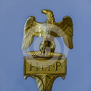 Golden ancient Roman sculpture of an eagle with the inscription H. et. P. lat: Heres ex testament posuit photo