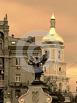 Golden angel with the wings and the church bell tower