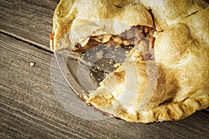 Golden Apple Pie on Rustic Barnwood With One Slice Gone