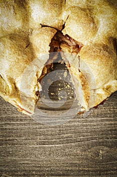 Golden Apple Pie on Rustic Barnwood With One Slice Gone