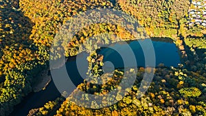 Golden autumn background, aerial view of forest with yellow trees and beautiful lake landscape from above, Kiev, Goloseevo forest