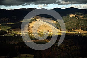 Golden autumn in the Carpathians. Mining arrays combined with trees with yellow leaves. Beautiful clouds and sun