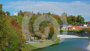 Golden autumn in ftown Bad Tolz. View of Isar river, trees, mountains, town and church. Bavaria, Germany.