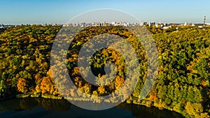 Golden autumn Kyiv cityscape, aerial drone view of city skyline and forest with yellow trees and beautiful landscape from above