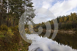 Golden autumn scene with river Gauja and surrounding colourful forest in October in Latvia