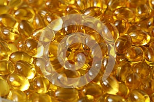 Golden background capsules Close up food supplement oil filled capsules suitable vitamin A, vitamin D3, fish oil, omega 3, 6, 9,