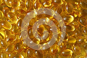 Golden background capsules Close up food supplement oil filled capsules suitable vitamin A, vitamin D3, fish oil, omega 3, 6, 9,