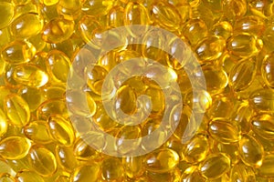 Golden background capsules Close up food supplement oil filled capsules suitable vitamin A, vitamin D3, fish oil, omega 3, 6, 9,