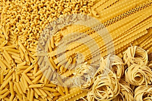 Golden background of dried pasta of various varieties