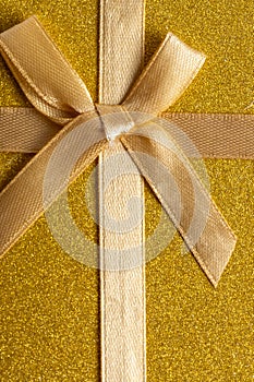 Golden background with ribbon and bow for christmas and new year.