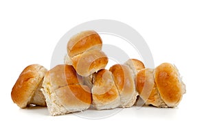 Golden baked dinner rolls on a white background