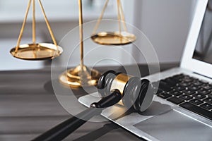 Golden balanced scale and gavel on desk with laptop in law office. equility