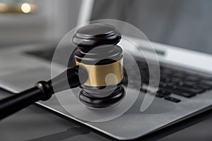 Golden balanced scale and gavel on desk with laptop in law office. equility